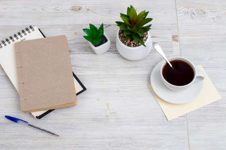 desk office with blank notepad, coffee cup and pen on wood table. Flat lay top view copy space.の写真素材