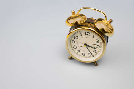 Gold alarm clock on gray background isolated. Copy spaceの写真素材