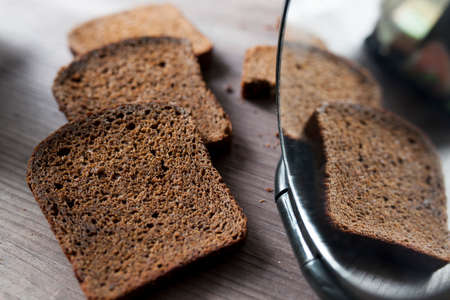 Sliced rye bread on cutting board. Whole grain rye bread with seeds on rustic background. Copy...
