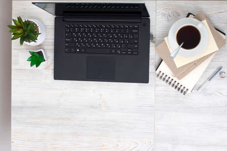 Office desk wood table of Business work place, notebook, artificial plant and coffee cup with copy space.の写真素材
