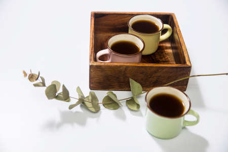 Mango wood wooden tray with four espresso coffee cups on the white background. Empty space