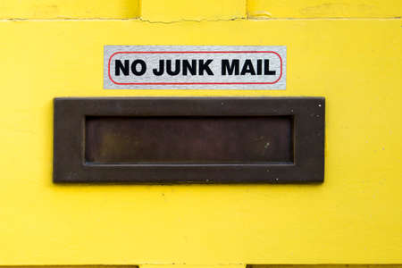 House letterbox with 'No junk mail' sign at a yellow vintage doorの写真素材