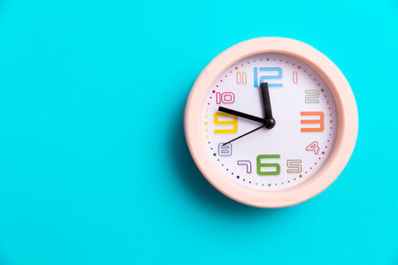 A round clock is on a blue background. Copy space. Ten to twelve