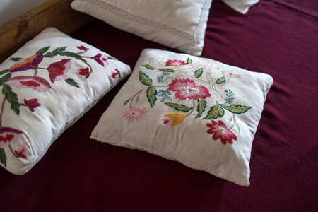 Embroidered satin stitch in the Russian style pillowcases on the pillows lying on the bedの写真素材