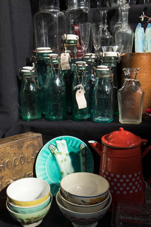London, UK - 20 September 2020 Glass bottles with corks, dusty wine glasses, tin coffee pots,...
