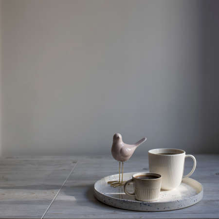 Minimalistic Scandinavian style. Minimalistic Scandinavian style. two cups of coffee of different sizes for two on a tray on the table.の写真素材