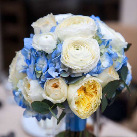 Wedding bouquet composed of blue hydrangea, white-yellow roses, creamy peony roses and ranunculusの写真素材