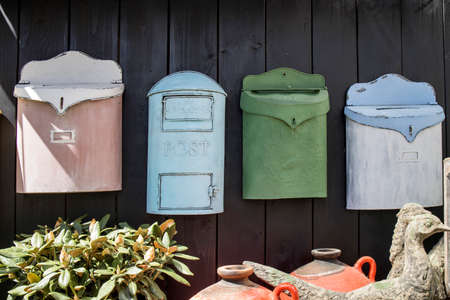 decorative mailboxes hanging on a shabby wall in the gardenの写真素材