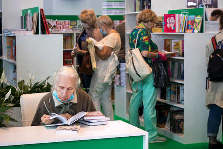 Moscow, Russia - 21 June 2021, Old woman reading book in bookstore