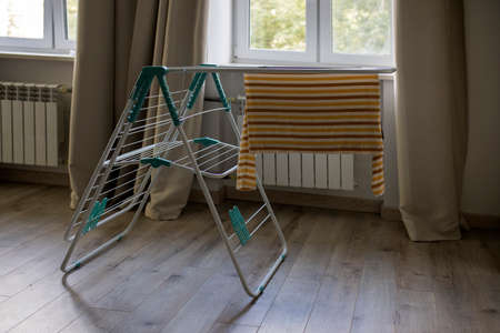 Dryer for clothes with a striped long-sleeved T-shirt in a beige interior against the background of...