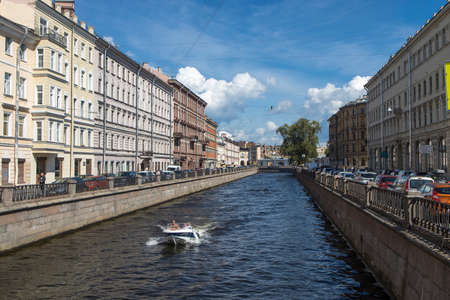 Saint PETERSBURG, RUSSIA-July, 15, 2021: Moika River embankment with moored boats with reflections in the water and historical buildings in the early summer morningのeditorial素材