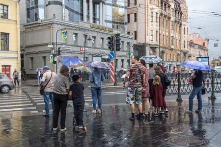 Saint Petersburg, Russia - 9 August 2021, People cross the road on a busy street in rainy dayのeditorial素材