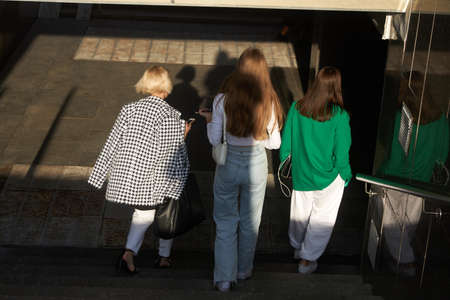 Moscow, Russia - 31 August, 2021, Three fashionably dressed unrecognizable girls go down the stairs to the underground passageのeditorial素材