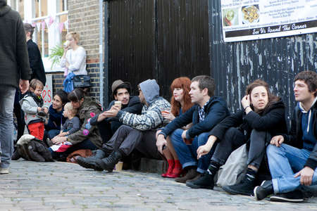 London, UK - 20 October 2021, Columbia Road Flower Market. Fashionable young people, hipsters sit on...