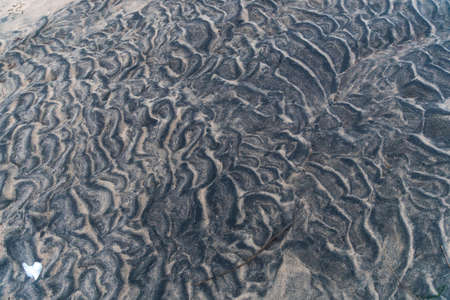 Black sand with traces of waves on the White Sea