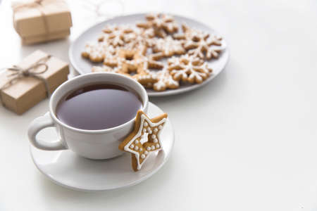 Cup of coffee with gingerbread christmas cookies in the form of stars on a white table. Copy spaceの写真素材