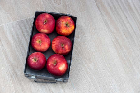 Six red apples on a zinc gray tray are on the ceramic table top. Space for text. Top view. Copy spaceの写真素材