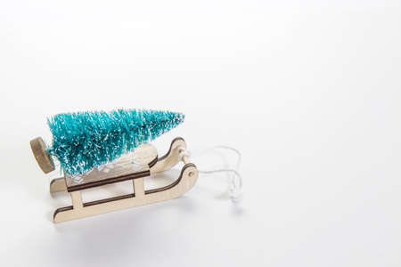 Wooden sleigh with decorative fir tree on white background. Christmas holidays. Copy space. Place...
