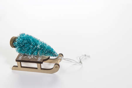 Wooden sleigh with decorative fir tree on white background. Christmas holidays. Copy space. Place...