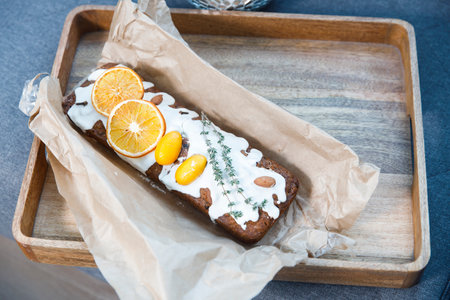 Traditional christmas cupcake garnished with dry orange wedges, clove spice and rosemary sprig in craft paperの写真素材