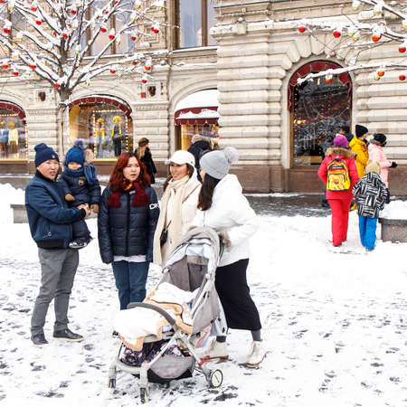 Moscow, Russia - 20 December 2021, GUM-fair on Red Square, Christmas market. A large family with a small child is photographed against the background of GUM. Square frameのeditorial素材