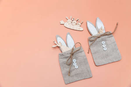 Family of funny hares cut out of plywood are on the yellow, orange, pink background. card design. copyspace. Place for textの写真素材