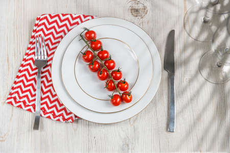 Serving plate, spoon, fork, knife and red napkin are on the wooden table. The concept of weight loss...