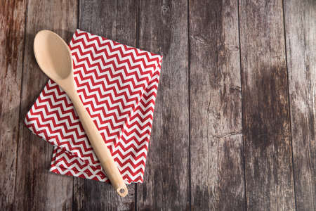 Kitchen towel napkin is on the brown wooden table. top view. maximum sharpness. knitted napkin in red and white zigzag. copy spaceの写真素材