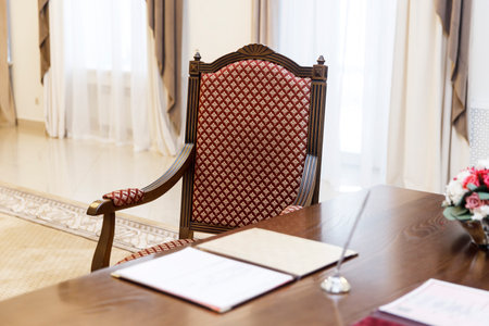 Standard wedding registration hall in Moscow. A red armchair in the Empire style at the wooden table, where the spouses sign the act of registering the wedding.の写真素材