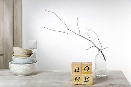 An unblown linden branch in a glass vase and four wooden cubes with space for text. Scandinavian style. copy textの写真素材