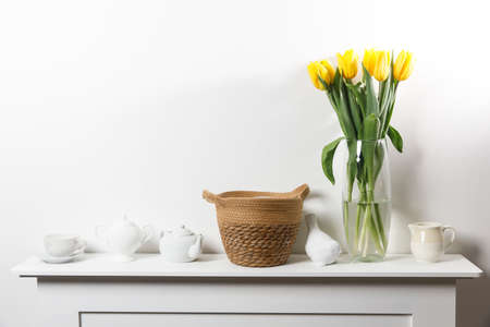 Bouquet of yellow tulip in the glass vase on white tableの写真素材