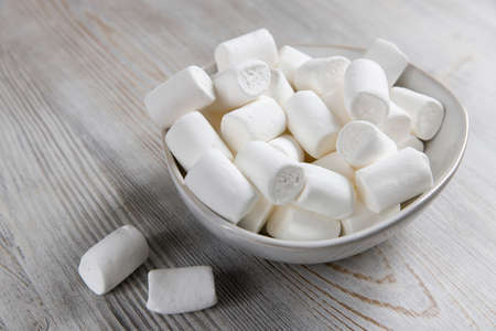 White marshmallows in a porcelain bowl on the tableの写真素材