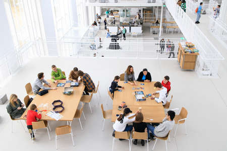 Foto de Moscow, Russia - 12 April 2022, Interior of GES-2, also known as MGES-2 and Tramvaynaya is a decommissioned power station on the Bolotnaya Embankment. Teenagers play board games at the tables - Imagen libre de derechos