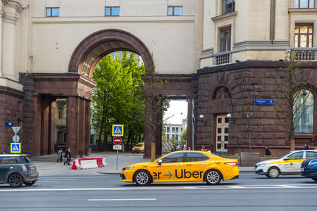 Moscow, Russia - 22 May 2022, Uber taxi rides along Tverskaya street in front of Stalin's houses