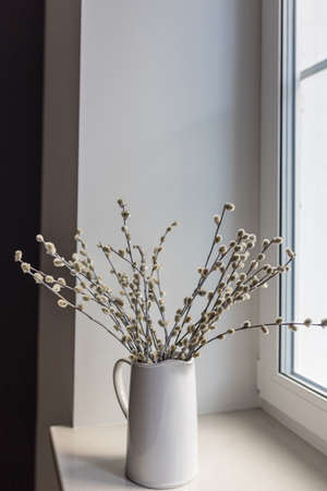 illow branches in a white ceramic jug and a mirrored disco ball on the windowsill as decoration before Easterの写真素材