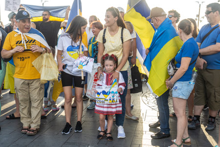 Tel Aviv, Israel - March 20, 2022, Protest against Russian aggression in Ukraine. A little girl in Ukrainian national dress holds a poster with the inscription Glory to Ukraineのeditorial素材