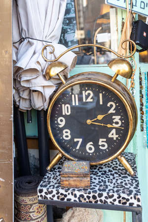 Haifa, Israel - 20 July 2022, Scene of the flea market, with sellers and shoppers, in downtown Haifa, Israel. Large alarm clock on a leopard chairの写真素材