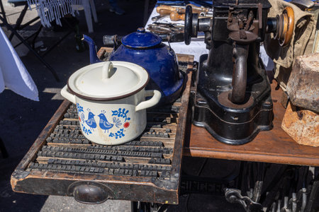 Haifa, Israel - 20 July 2022, Scene of the flea market, with sellers and shoppers, in downtown Haifa, Israel. Enameled white saucepan on a typographic boardのeditorial素材