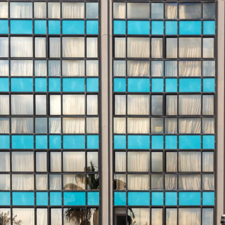 Old soviet constructivist industrial building exterior facade with large windows, blue glass bricks