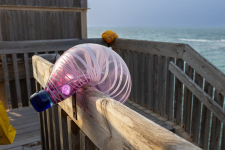 CAESAREA, Israel - August 11 2022, multi-colored glass oval-shaped balls lamps on the railing of the fence as a decoration. Modern designのeditorial素材