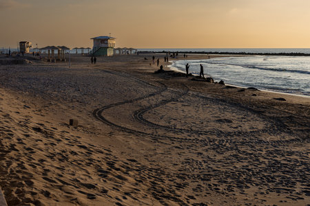 Haifa, Israel - January 20, 2023, Dado beach at sunset. People walk along the beach. Lifeguard booths.のeditorial素材