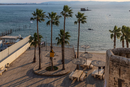 Acre, Israel - January 08, 2023: Sunset view of the Horses beach, the sea wall and the fishing port, with locals and visitors, in the old city of Acre (Akko), Israelのeditorial素材