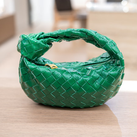 Green, mini leather round hand bag is on the tableの写真素材