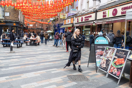 London,UK -18 April 2023, China Town is decorated by Chinese lanterns and lots of tourists and Londoners walking on the street. ChinaTown was established in 1880 by Chinese sailors and tradersのeditorial素材