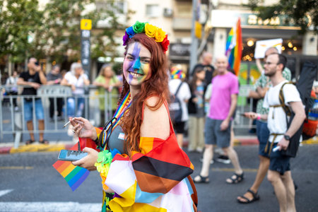 Haifa, Israel - June 24, 2023: People with protest signs in preparation to the annual LGBTQ pride parade. Girl waving a rainbow flagのeditorial素材