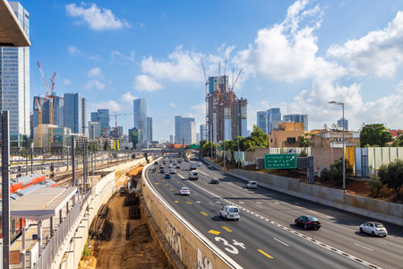 Tel-Aviv, Israel -11 July 2023, Modern glass skyscrapers. Moving cars and trains near the hahagana train stationのeditorial素材