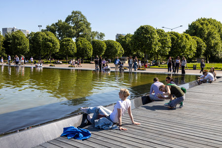 Moscow, Russia - May 2023, Gorky Central Park of Culture and Leisure. People are resting on the pier near the artificial pond near Fontain. Happy coupleのeditorial素材