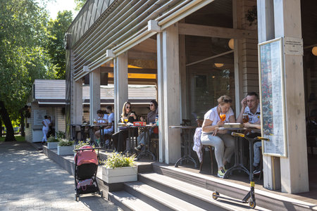 Moscow, Russia - 23 June 2023, Cafe on the Muzeon embankment in the summer. People enjoy the view of the Moscow river and fountains. Gorky Central Park of Culture and Leisureのeditorial素材