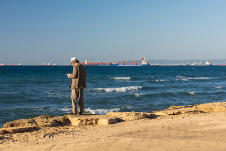 Haifa, Israel - September 27, 2023, An Orthodox man wearing a knitted kippah reads a prayer on the Jewish New Year Rosh Hashanah on the shores of the Mediterranean Sea.のeditorial素材