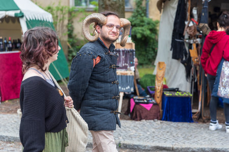 Berlin, Germany - March 30, 2024: Medieval Fair: Visitors to the knight's tournament. A young man...